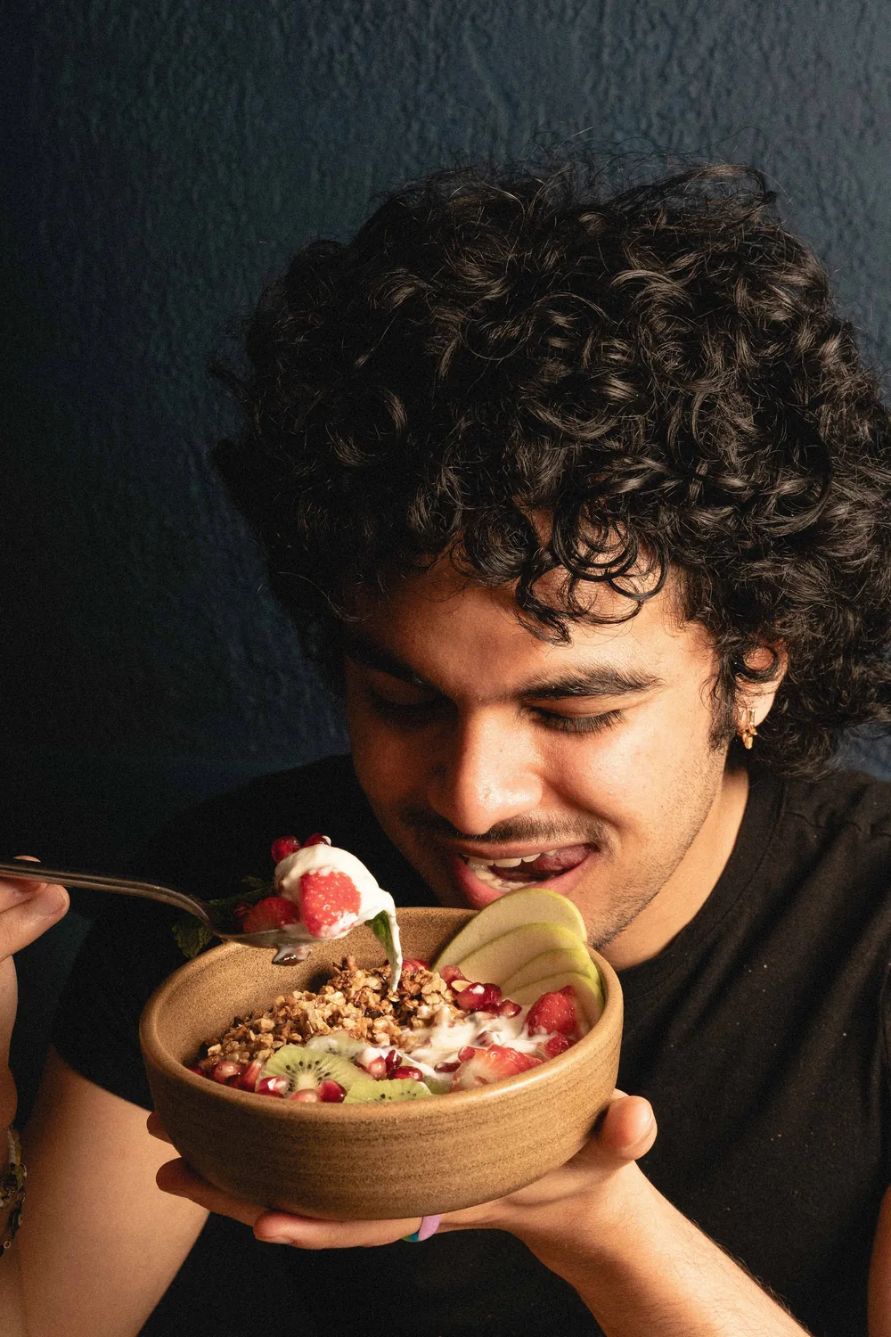 Uomo che gusta una colazione abbondante con granola fatto in casa, frutta fresca e yogurt da Marlette Abbesses