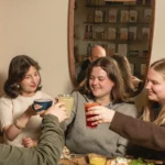 Quatre amies rient autour d'une table chez Marlette Abbesses, dégustant des boissons et des assiettes gourmandes faites maison