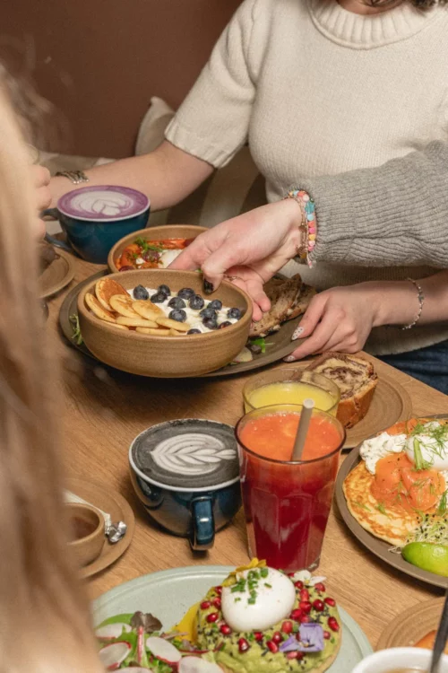 Brunch convivial à Marlette Abbesses : pancakes bio aux myrtilles, café latte et jus frais partagés entre amies