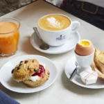 Brunch gourmand chez Marlette : café au lait art déco, scone bio maison à la confiture, œuf à la coque et tartines grillées
