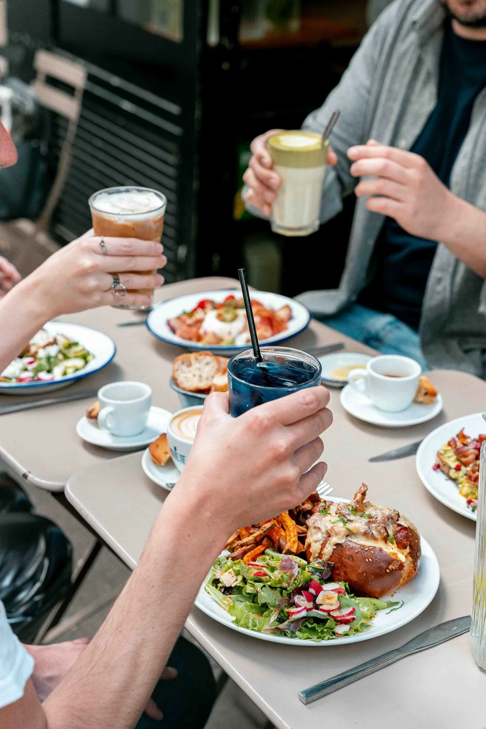 Moment de partage chaleureux autour d'une table Marlette : café, boisson fraîche et assiettes généreuses de brunch fait-maison