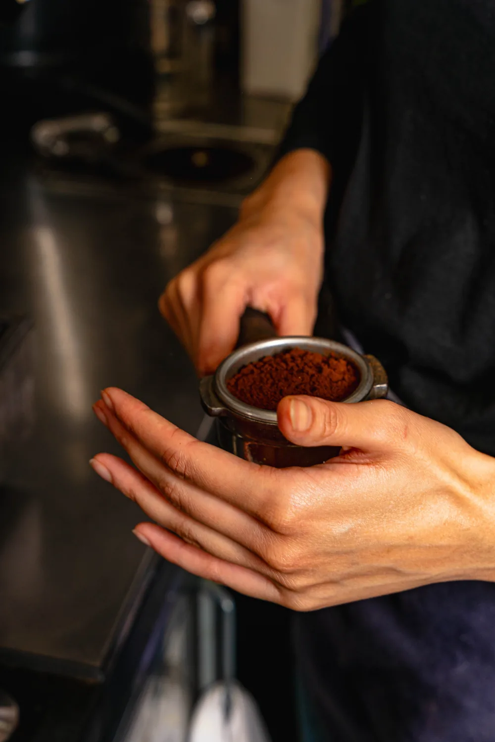 Barista Marlette che tiene un portafiltro pieno di caffè macinato fresco