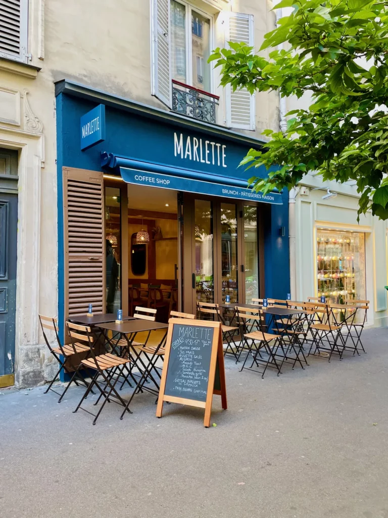 Façade bleue de Marlette coffee shop rue des Abbesses avec terrasse conviviale et menu du jour