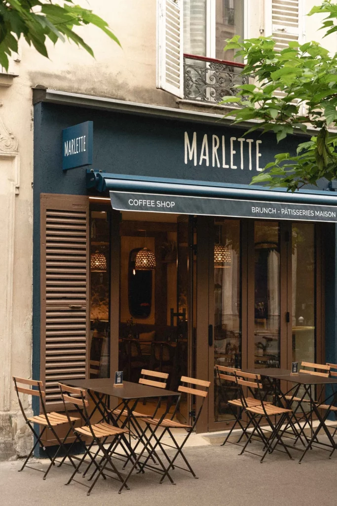 Façade élégante du coffee shop Marlette rue des Abbesses à Paris, avec terrasse conviviale et pâtisseries maison