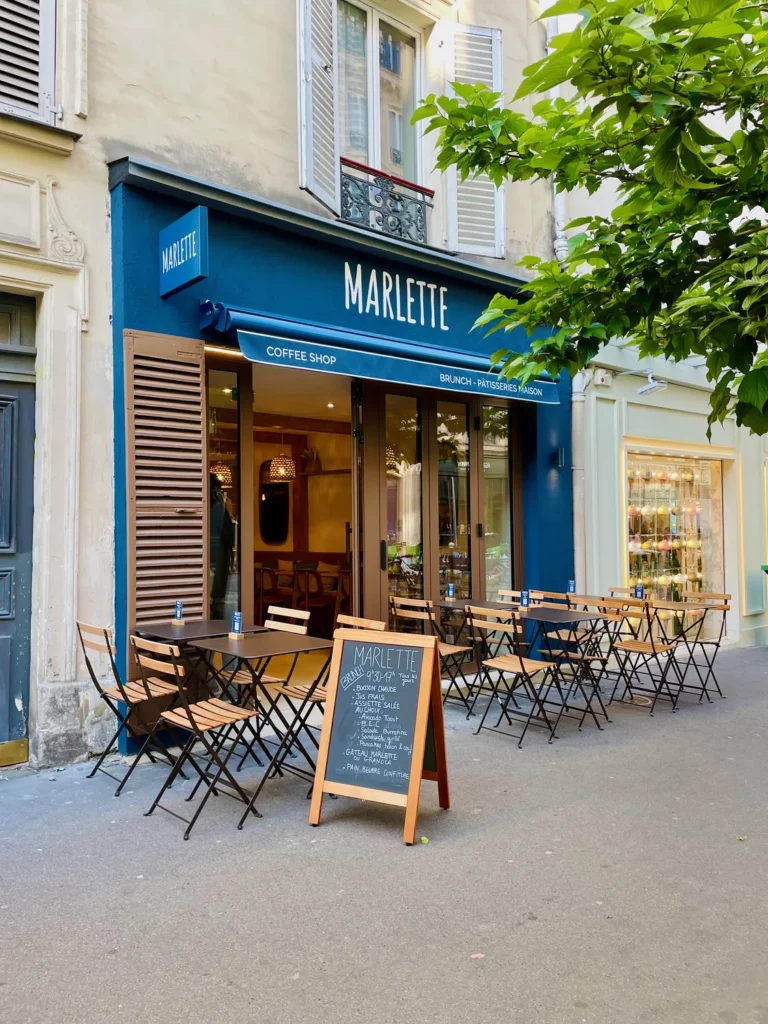 Façade bleue du coffee shop Marlette rue des Abbesses à Paris avec terrasse conviviale et menu du jour