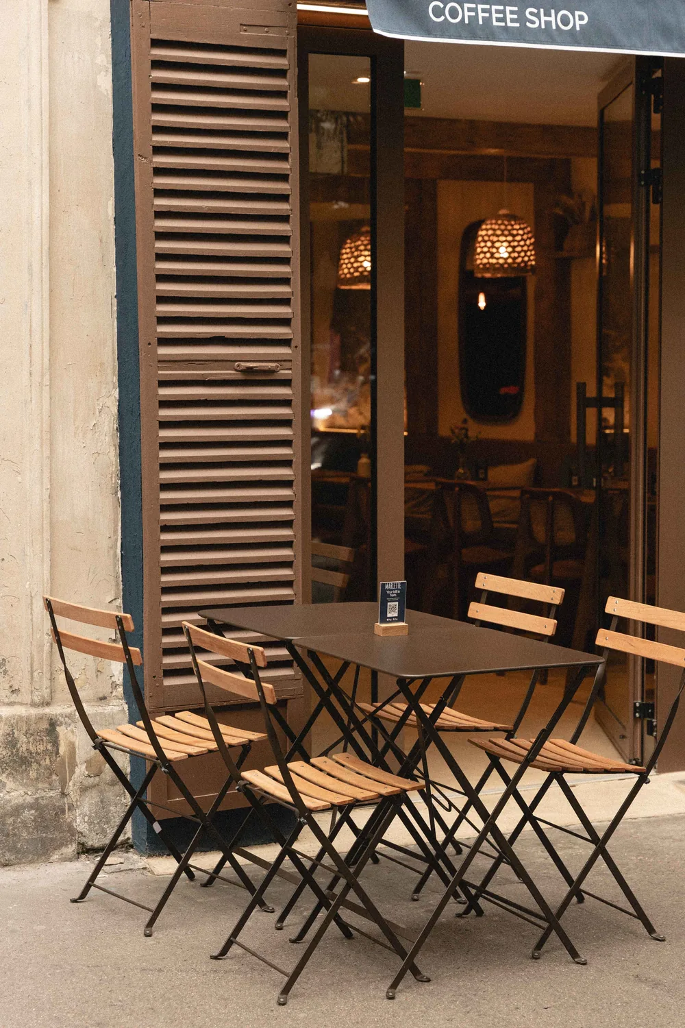 Terrasse chaleureuse du coffee shop Marlette rue des Abbesses à Montmartre, avec tables et chaises en bois