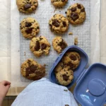 Cookies aux pépites de chocolat bio faits maison, fraîchement préparés sur papier sulfurisé