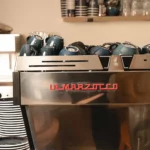 Machine à espresso La Marzocco professionnelle chez Marlette Abbesses, tasses bleues en attente