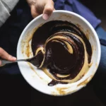 Cuillère plongeant dans un bol de pâte à chocolat gourmande et généreuse, fait-maison chez Marlette