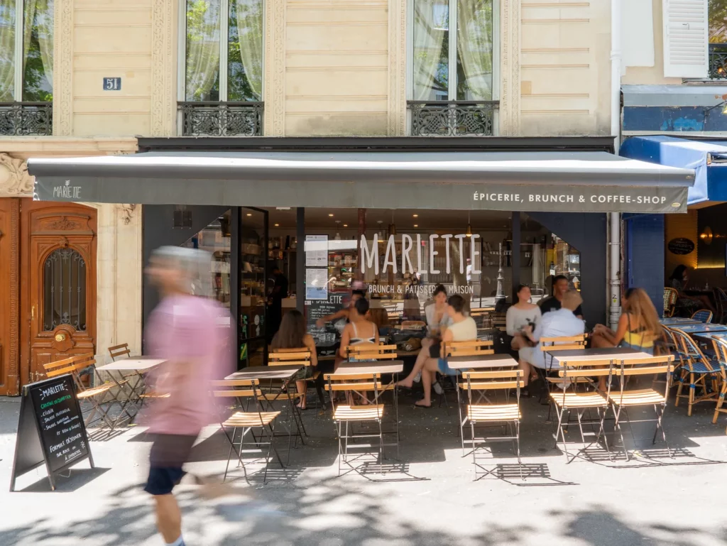 Devanture du coffee-shop Marlette rue des Martyrs à Pigalle, avec clients attablés en terrasse sous le parasol, par beau temps à Paris