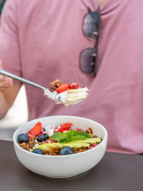 Bol de granola maison garni de fruits frais, miel et feuille de menthe, dégusté chez Marlette aux Martyrs à Pigalle