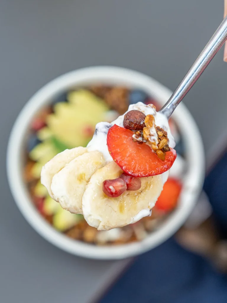 Cuillère prélevant du granola maison, fruits frais et yaourt d'un bol de brunch Marlette aux Martyrs, Pigalle