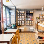 Intérieur du coffee shop Marlette aux Martyrs avec étagères de préparations bio, tables en bois et grandes vitrines donnant sur la rue de Pigalle