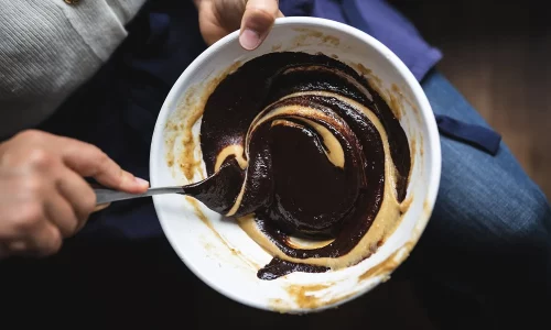 Cuillère plongée dans un bol de chocolat savoureux fait-maison chez Marlette Abbesses