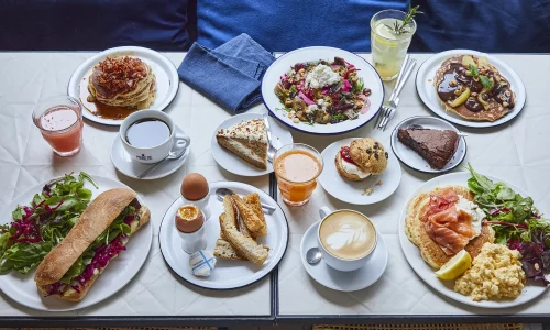 Table de brunch Marlette avec pancakes, pâtisseries bio, café et jus frais servis à Paris