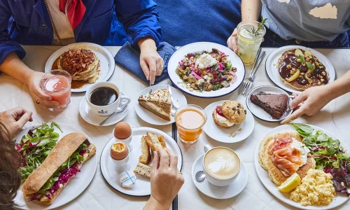 Table de brunch convivial chez Marlette avec pancakes, œufs, pâtisseries bio et cafés généreux partagés entre amis