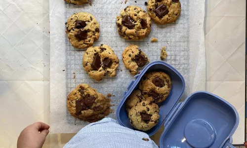 Cookies aux pépites de chocolat bio faits maison, fraîchement préparés sur papier sulfurisé