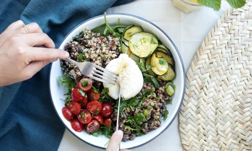 Assiette généreuse de salade fraîche avec quinoa, chèvre frais, tomates et concombre - déjeuner gourmand